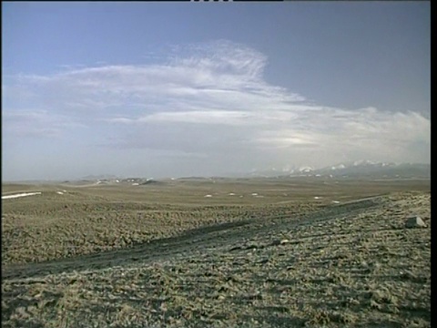 寒冷的冬季怀俄明平原与雪山在背景盘留下了更广阔的平原视频素材