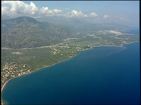 在平静的蓝色爱琴海和爱琴海岛屿的海岸线上跟踪前进视频素材