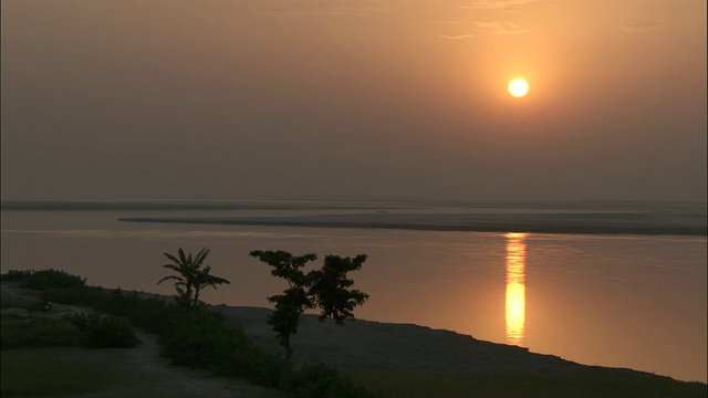 宽阔的河流上金色的夕阳。高清。视频素材