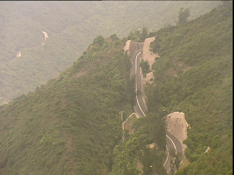 汽车行驶在一条切入香港山腰的道路上视频素材