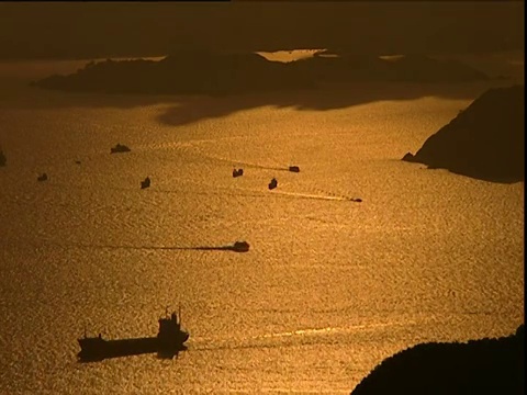 橙色的天空倒映在香港海港，油船和船只的剪影穿过视频素材