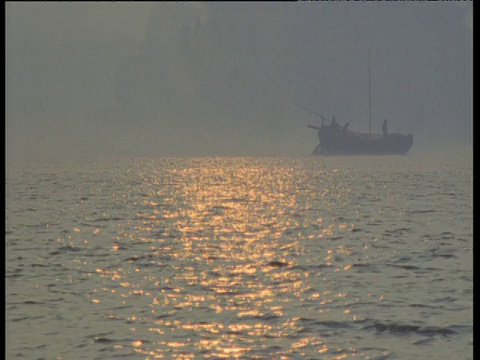 印度的恒河上，渔船在夕阳的映照下航行视频素材