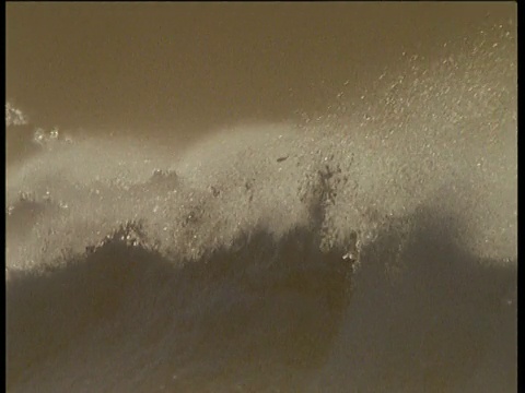 狂暴的海浪和浪花在暴风雨的海岸，橙色的光，爱尔兰视频素材