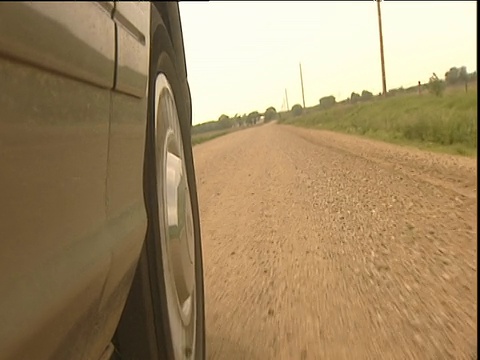 地平线反映在汽车轮毂盖沿尘土飞扬的道路行驶视频素材