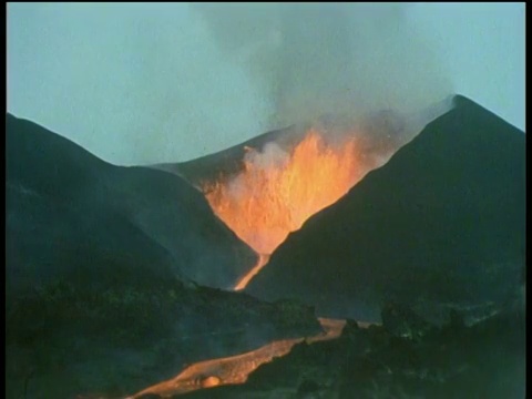 橙色的熔岩从火山喷发到空气中喷涌而出，火山与熔岩流下山视频素材