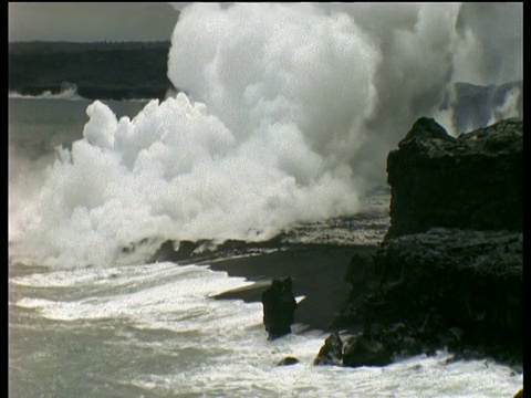 随着海浪撞击岩石，夏威夷海岸地幔柱冒出滚滚浓烟视频素材