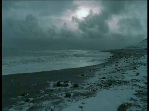 加拿大霍尔曼岛，海浪拍打着白雪覆盖的海滩视频素材