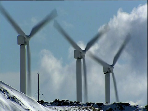 三个风力涡轮机在约克郡白雪覆盖的山丘上转动视频素材