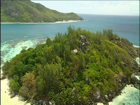 在Seychelles，绿松石色的海洋中，被白色沙滩包围的植被繁茂的岛屿视频素材