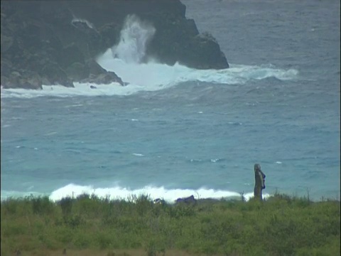 海浪打破岩石与摩埃石像前景复活节岛视频素材