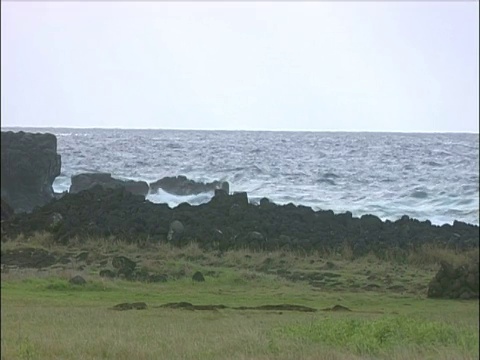 潘正越过海浪冲击复活节岛的岩石视频素材