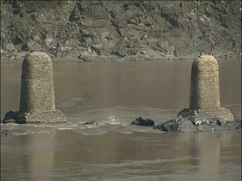 河水流经堤岸上的加固建筑和石柱视频素材