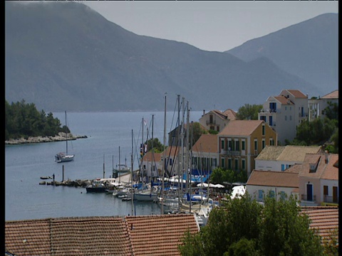 一艘小船从海湾驶出，背景是Fiscardo Cephalonia的多山岛屿视频素材