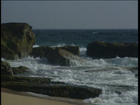 海浪拍打着岩石，阳光在Costa De La Luz的水面上闪闪发光视频素材