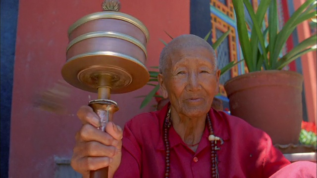 一个女人转动着她的祈祷轮。高清。视频素材