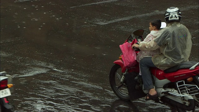 摩托车在一个下雨的十字路口停了下来。高清。视频素材