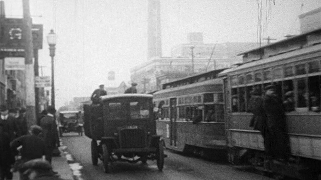 1910年代的汽车和电车在城市街道上的交通/人们在人行道上行走/纪录片视频素材