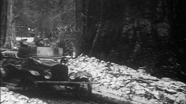 1910年的B/W，两个人在崎岖的森林道路上开车/一个点/纪录片视频素材