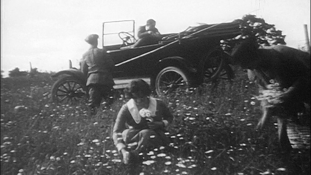 1910年代的人们在田野里摘花/在车里做背景/纪录片视频素材