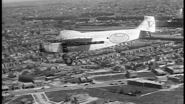 1927年空中空对空小型斯托特航空公司飞机低空飞越郊区/新闻短片视频素材