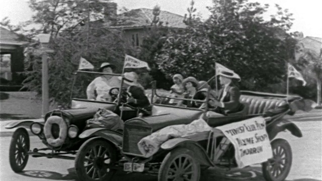 1927年，男人肩并肩爬进敞篷车，然后沿着街道起飞视频素材