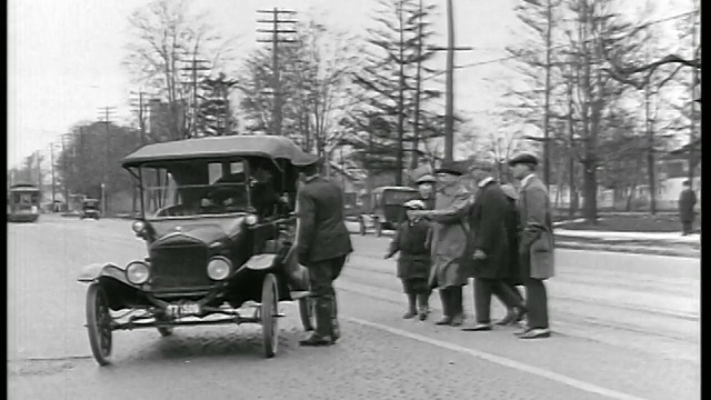 一辆1919年的B/W汽车几乎撞到站在“安全区域”街道上的人/交警训斥了他视频素材