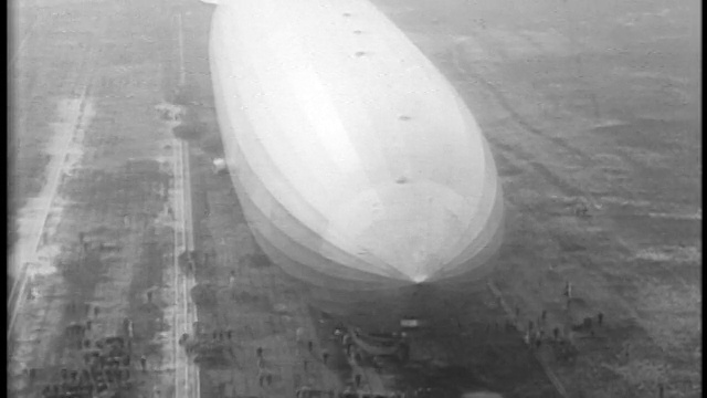 1929年空中的Graf Zeppelin在地面上低飞/人们在旁边散步/ Lakehurst, NJ视频素材