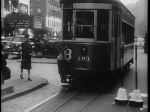 B/W 1939年，城市街道上的后视镜电车离开摄像机/纽约市/纪录片视频素材