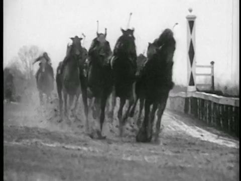 1935年，骑师骑着马在赛道上经过摄影机视频素材