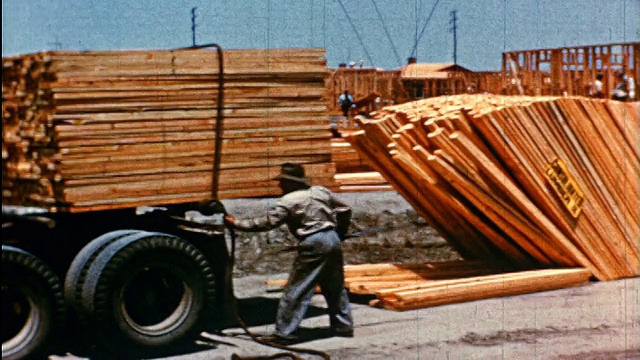 1950年，工人从卡车/工厂卸载木材视频素材