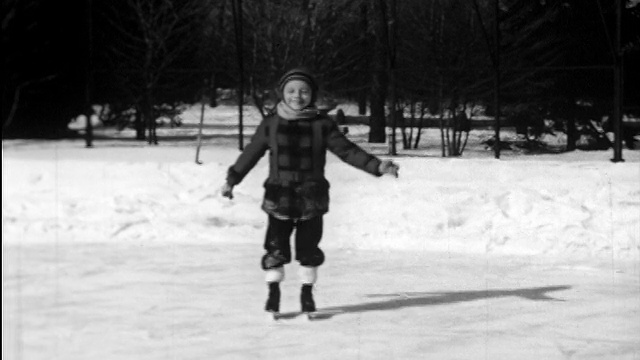 1948年男孩对着摄像机在池塘上滑冰/他摔倒了/指路视频素材