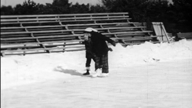 1948年潘男孩+女孩手牵手+在池塘上滑冰/教学视频素材