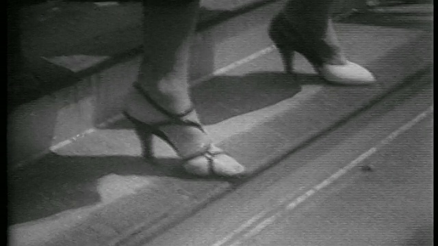 1953 b.w close up feet of women in high heel shoes walking down outside /新闻片视频素材