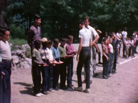 1964年PAN男露营辅导员在户外/家庭电影中检查男孩们的手视频素材