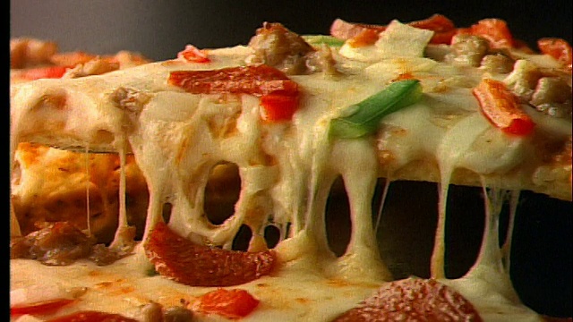 close up PAN + zoom out of pizza with many topings / slice being lift .接近PAN +缩放出许多浇头/片的披萨视频素材