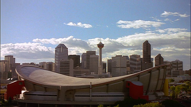 从卡尔加里塔(Calgary Tower)缩小到卡尔加里天际线/前景中的马鞍屋(Saddledome) /加拿大阿尔伯塔视频素材