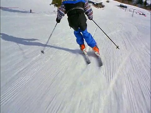 滑雪者从后面的人滑下斜坡的视角视频素材