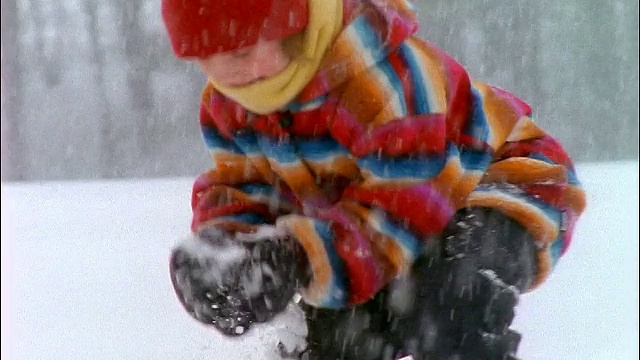 慢镜头近距离女孩扔雪球在暴风雪视频素材