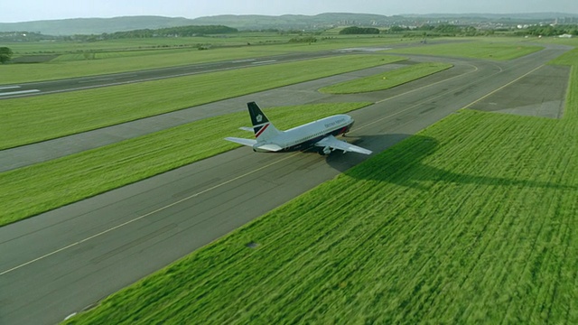 英国航空737在苏格兰格拉斯哥机场跑道上滑行的空中慢镜头视频素材