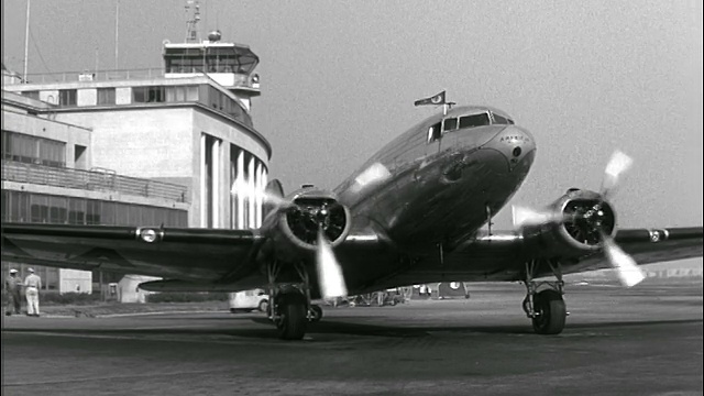 1946年双螺旋桨旗舰航空公司飞机滑行到机场附近的一个停靠点视频素材