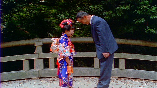 慢镜头中年日本男人和女孩在户外相互鞠躬视频素材