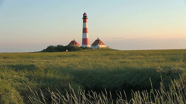 日落时从草地上看到的Westerhever灯塔，北弗里斯兰瓦登海/ Westerhever，石勒苏益格荷尔斯泰因，德国视频素材