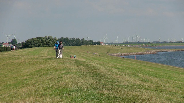 拍摄照片的人们和风车附近的eidersperrwerk, Dithmarschen, North Sea / tonning，石勒苏wig Holstein，德国视频素材