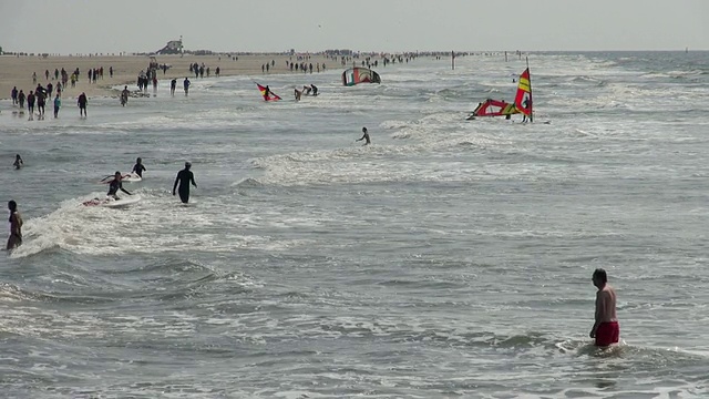 人们在北海北弗里斯兰海滩游泳和冲浪，/圣彼得奥尔丁，石勒苏益格荷尔斯泰因，德国视频素材