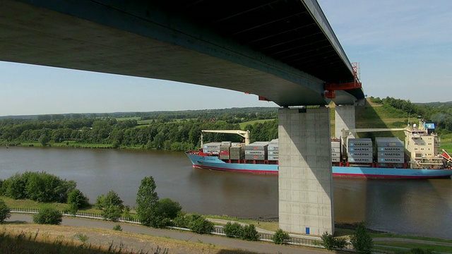 德国Schlewig Holstein Dithmarschen / Hochdonn附近Kiel Canal (Nord Ostsse Kanal)的集装箱船从桥上驶过视频素材