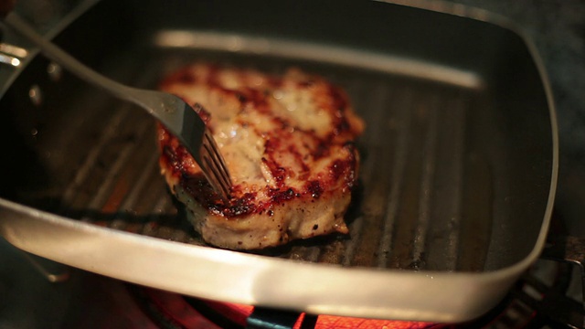 在平底锅里煎的猪肉排。视频素材