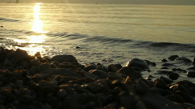 日出时，海水拍打着加利利海的岩石海岸视频素材