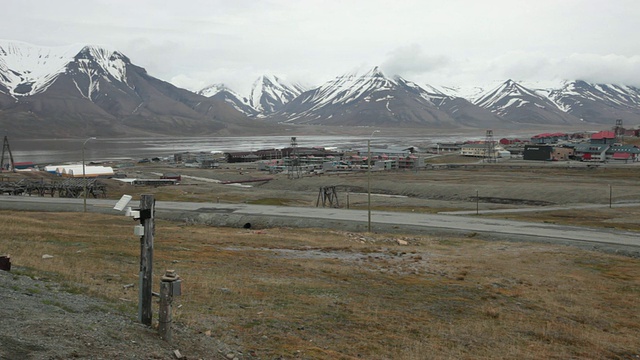 朗伊尔城(Longyearbyen)是挪威斯瓦尔巴特群岛(Norwegian Svalbard)的首府，是人口最多的地区，背景是白雪覆盖的群山视频素材