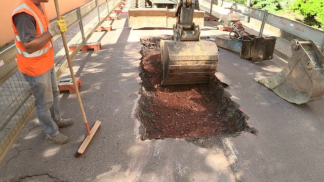 德国莱茵兰-普法尔茨Saarburg污水管道工地的工人在街道上雕刻视频素材