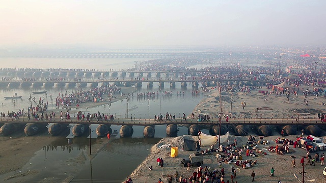 浮桥横跨浅水，朝圣者可以在岸边进行各种各样的活动。Kumbh梅拉、印度视频素材